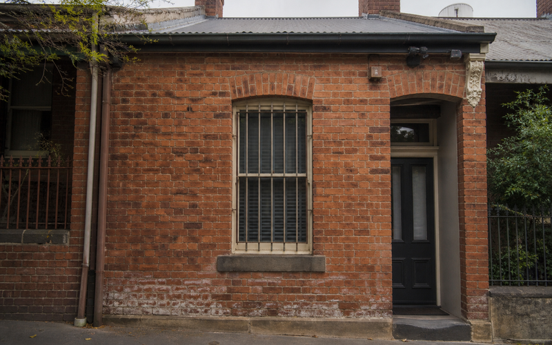 Heritage Sydney brick terrace facade with base damp staining - brick repair context