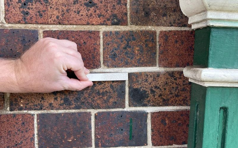 Checking a mortar sample against heritage brickwork during a repointing assessment