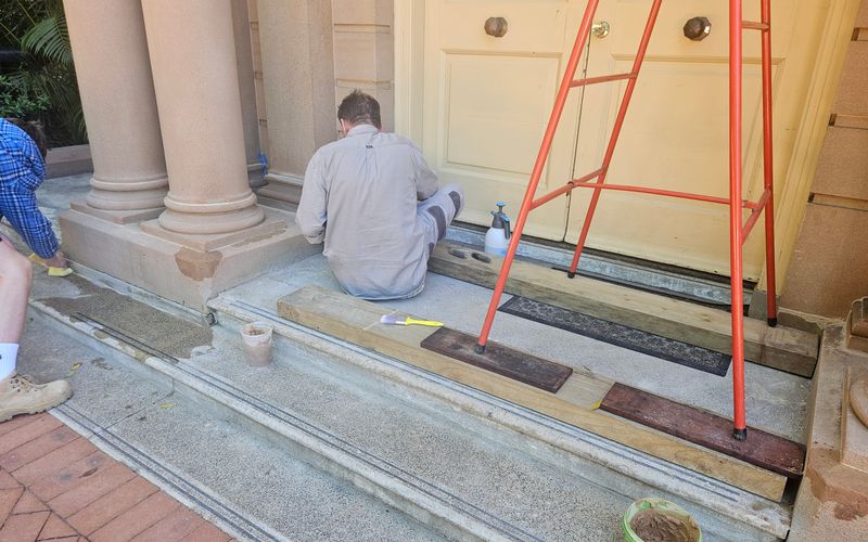 Repair and maintenance work under way at a sandstone-columned heritage entrance porch