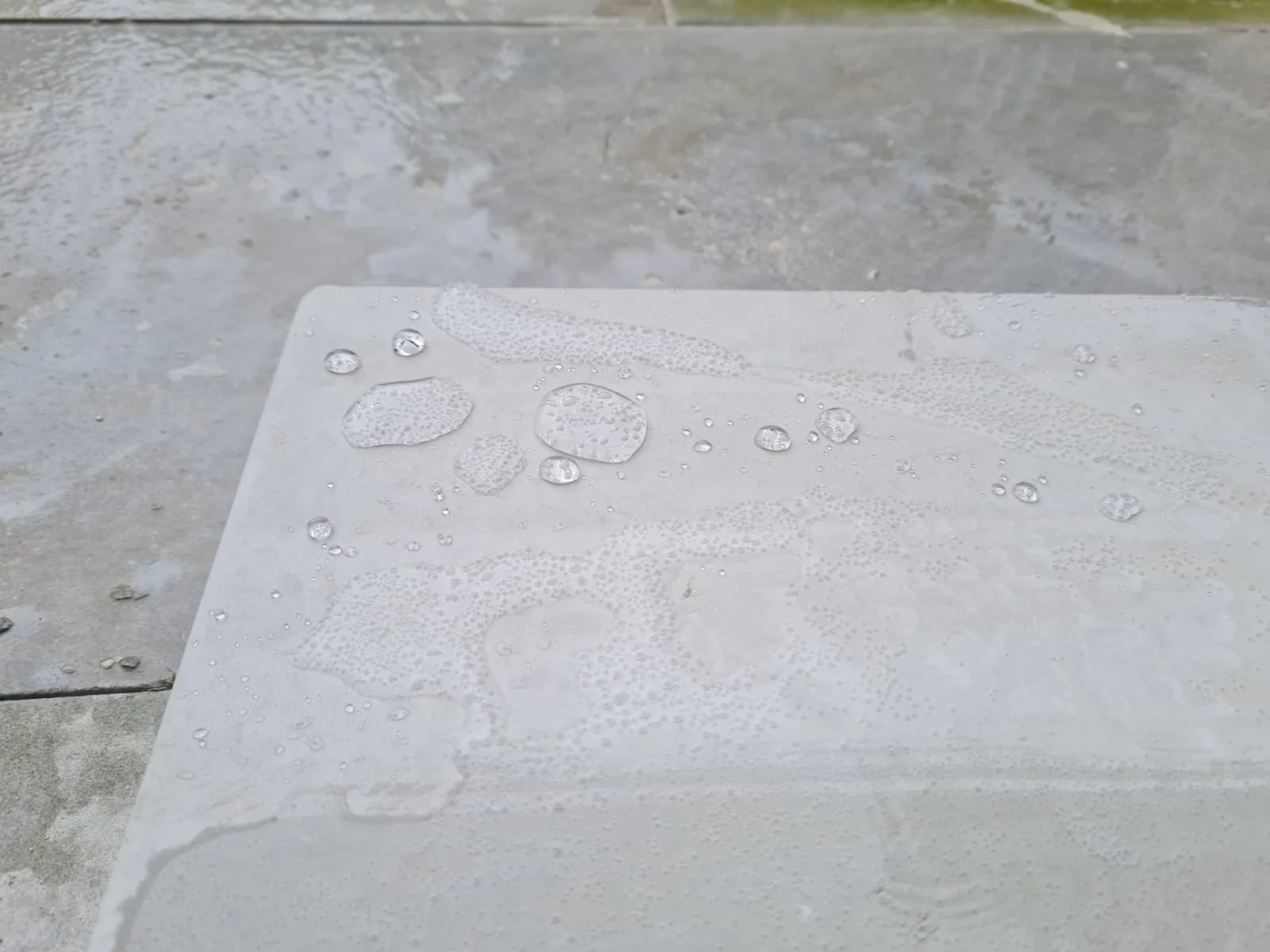 Water beading on a freshly treated sandstone surface — a breathable sealer shedding water without trapping moisture
